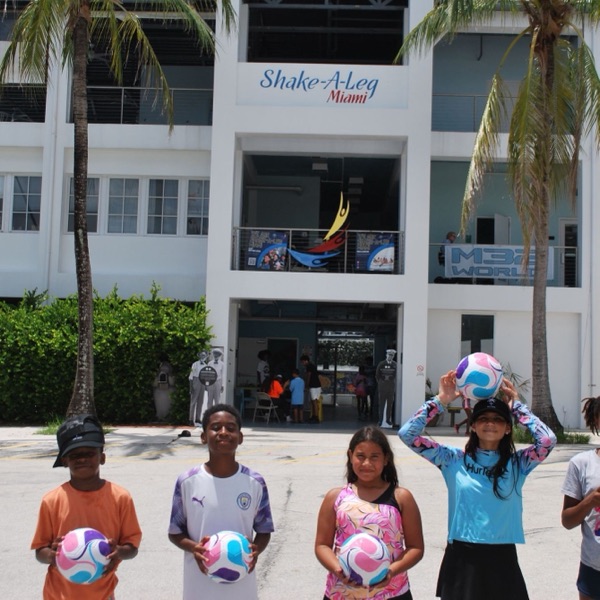 Kids holding new soccer balls outside Shake-A-Leg Miami